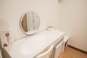 een witte badkamer met een spiegel en een wastafel bij Wantanee Ville วันทนีย์วิลล์ in Ban Wang Sai