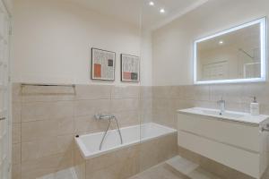 ein Badezimmer mit Badewanne und Waschbecken in der Unterkunft 2 Bedroom Apartment - Terrace & Sea View - Los Gigantes in Acantilado de los Gigantes + 29 Fotos