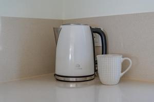 eine Kaffeekanne und eine Tasse auf der Theke in der Unterkunft 2 Bedroom Apartment - Terrace & Sea View - Los Gigantes in Acantilado de los Gigantes