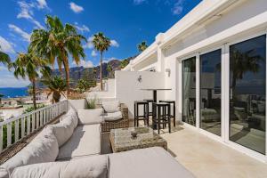 eine Terrasse mit einer Couch und einem Tisch auf einem Balkon in der Unterkunft 2 Bedroom Apartment - Terrace & Sea View - Los Gigantes in Acantilado de los Gigantes