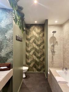 een badkamer met een bad, een toilet en een wastafel bij Hotel de Charme Le Sud Bretagne in Pornichet