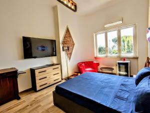 a bedroom with a bed and a flat screen tv at - SeaFront Deluxe Home- [Private Jacuzzi & Garden] in Marina di Carrara
