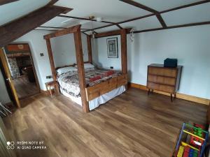 um quarto com uma cama e piso em madeira em The Poets Rest...where comfort and tradition meet. em Moville