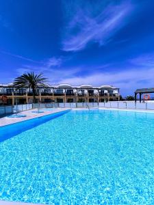 una gran piscina azul con edificios en el fondo en Apartamento Reload Complex Amaya Fuerteventura, en Costa de Antigua