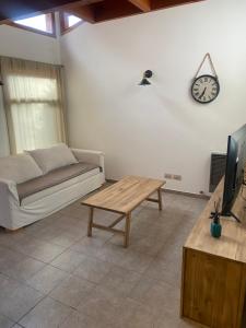 拉安戈斯圖拉鎮的住宿－Casitas patagonicas，客厅配有沙发和墙上的时钟
