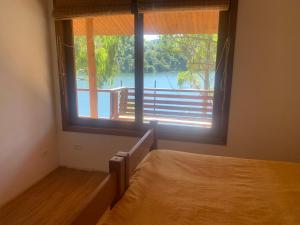 a bedroom with a bed and a large window at Casa INTI Refugio Romantico Pague duas noites minimo e a terceira e brinde, menos feriados in Natividade da Serra