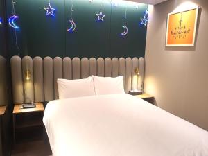 ein Schlafzimmer mit einem großen weißen Bett und Sternen an der Wand in der Unterkunft Raviens라비앙즈 in Busan