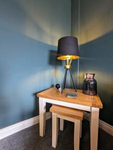 a table with a lamp and a coffee maker on it at Cockle Cottage - Crabpot Cottages in Cromer