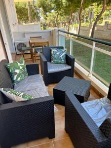 a screened porch with chairs and tables and a table at Family Relax Salou in Salou