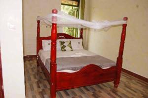 1 cama roja con dosel en una habitación en Loginecoresort, en Lukunyu