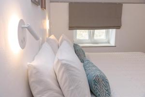 a bedroom with a bed with white pillows and a window at Agnantio in Tinos