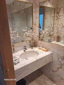 een badkamer met een wastafel en een grote spiegel bij Diyar AlBahr ديار البحر in Jeddah