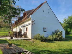 um chalé com um telhado de palha e uma mesa em Traditional cottage at Lake Balaton em Vászoly