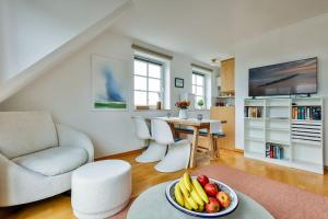 a living room with a bowl of fruit on a table at Ferienwohnung-Sandblume-mit-Meerblick in Hörnum