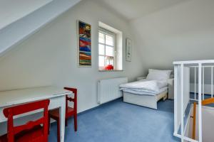 a room with a desk and a bed and a window at Ferienwohnung-Sandblume-mit-Meerblick in Hörnum