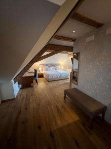a attic bedroom with a bed and a desk at La Belle-Croix in Romont