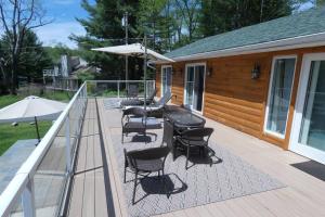 a deck with a table and chairs and an umbrella at Sun Drenched Lakefront Cove in Monticello