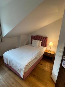 a bedroom with a large white bed and a lamp at La Belle-Croix in Romont