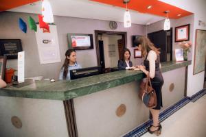 a woman standing at a counter in a restaurant at Ibis Fes in F&egrave;s