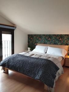 a bedroom with a large bed with a green wall at Isla in Oiartzun