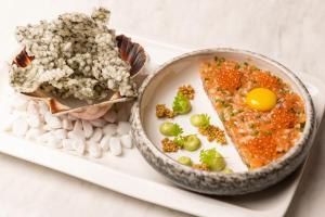 a plate of food with an egg and a bowl of food at Grand Poet Hotel and SPA by Semarah in Rīga