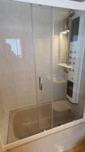 a shower with a glass door in a bathroom at Ibón de espelunciecha in Formigal +6 photos