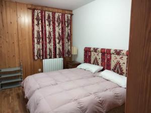 a bedroom with a large bed and a window at Ibón de espelunciecha in Formigal