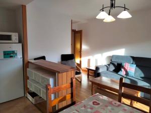 a living room with a blue couch and a kitchen at Ibón de espelunciecha in Formigal