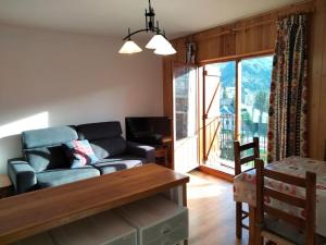 a living room with a couch and a table at Ibón de espelunciecha in Formigal