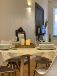 una mesa de comedor con platos y copas de vino en Grand appartement de charme proche Cité, en Carcassonne