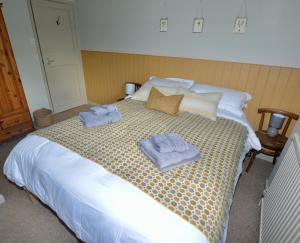 sypialnia z łóżkiem z ręcznikami w obiekcie Gryngolet Cottage - with Artist Studio - Crabpot Cottages Sheringham w mieście Aylmerton
