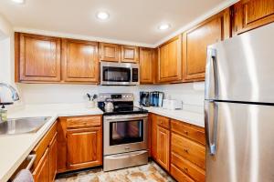 a kitchen with wooden cabinets and stainless steel appliances at Sterling Ridge 18 in Warren