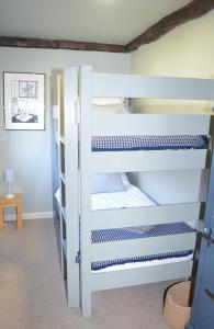 a bunk bed with blue and white bunk beds at Gryngolet Cottage - with Artist Studio - Crabpot Cottages Sheringham in Aylmerton