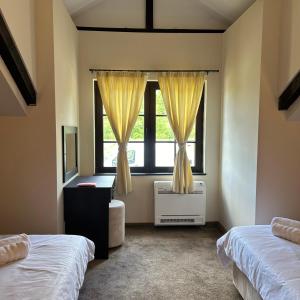 sypialnia z 2 łóżkami i oknem w obiekcie Геша Хил Парк СН21 w mieście Balaleya