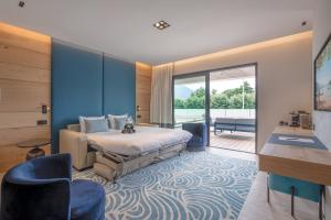 een slaapkamer met een bed met een blauwe muur bij Rivage Hôtel & Spa Annecy in Annecy