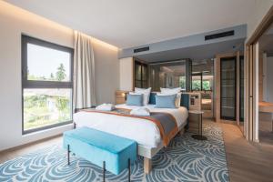 a bedroom with a large bed and a large window at Rivage Hôtel & Spa Annecy in Annecy