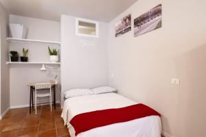 a small bedroom with a bed and a table at bilocale centro storico Cesena Casa Ludo in Cesena