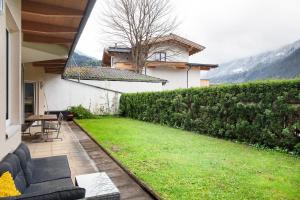 a backyard with a couch and a green lawn at Apartment Tux in Mayrhofen