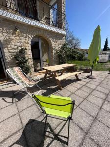 dos sillas y una mesa de picnic y una mesa y un banco en Appartement les Mésanges en Le Poët-Laval