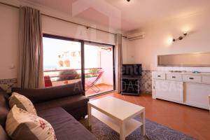 una sala de estar con un sofá y una mesa en Sofia Beach Apartment by ACasaDasCasas, en Ericeira
