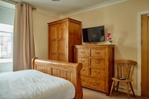 a bedroom with a bed and a dresser with a television at The Pennine Inn in Kirkby Stephen