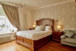 um quarto com uma cama, um sofá e um lustre em The Pennine Inn em Kirkby Stephen