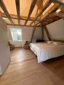 um quarto com uma cama num quarto com pisos em madeira em Demeure La Lande Fleurie em Feneu