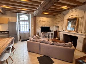 uma sala de estar com um sofá e uma lareira em Demeure La Lande Fleurie em Feneu