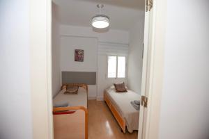 een kleine kamer met 2 bedden en een raam bij Precioso Apartamento en Valencia in Paterna