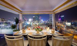 un comedor con vistas a la ciudad por la noche en Winsuites Saigon - Luxury Boutique Hotel, en Ho Chi Minh