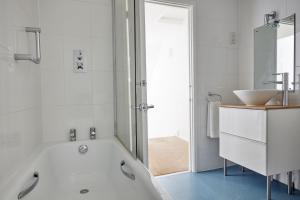 ein weißes Badezimmer mit Badewanne und Waschbecken in der Unterkunft Selwood Cottage in Beckington + 20 Fotos