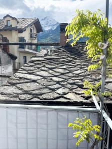 a tile roof on a building with mountains in the background at You and Me nel cuore antico di Aosta in Aosta