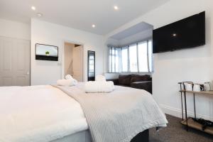 a bedroom with a large white bed with towels on it at The Nook - Self Serviced Accommodation in St Ives