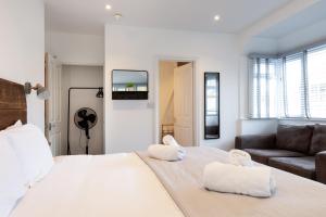a bedroom with a large white bed and a couch at The Nook - Self Serviced Accommodation in St Ives